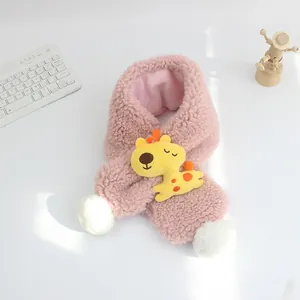 Dettaglio sciarpa in lana d'agnello rosa con giraffa gialla e pompon bianchi soffici