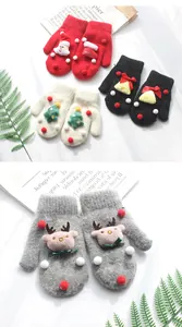 Dettaglio di muffole natalizie in maglia con Babbo Natale 3D e ricami festivi