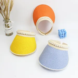 Detail of straw sun visors with pearl trim in yellow, orange and blue colors