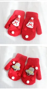 Detail of red knit mittens featuring 3D Santa and bell ornaments for winter warmth