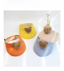 Close-up of children's straw sun hats in four colors with cute teddy bear details