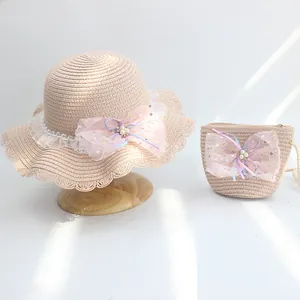 Detail of pink straw hat and matching bag with lace flower and pearl mesh bow
