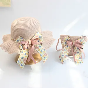 Detail der Strohtextur und floralen Schleife am rosa Sommerhut und Tasche für Mädchen