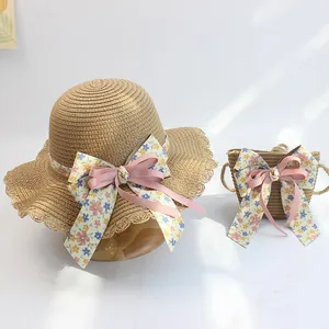 Detailaufnahme von Strohhut und passender Tasche mit lila Blumenschleifen für Mädchen