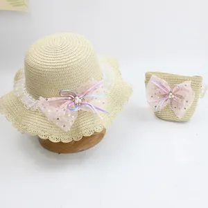 Detail of kids straw sun hat and matching mini bag with pink mesh bow and pearls