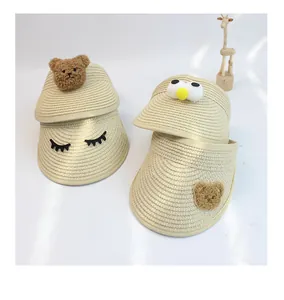 Detail of four straw sun visors for kids with cute bear and cartoon eye decorations