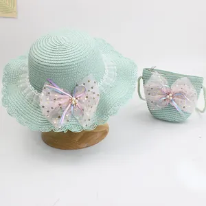 Detail of green kids straw hat and matching bag set with pink mesh bows and pearls