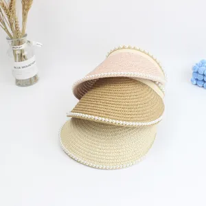 Detail of straw sun visor headbands with pearl trim in pink, khaki, and beige tones