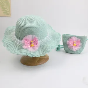 Detail view of woven straw hat and matching bag with mesh flower and cartoon girl doll