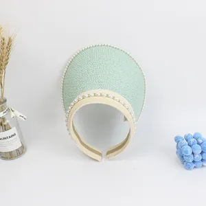 Detail of mint green straw sun visor with elegant double row pearl trim decoration