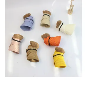 Detail of colorful foldable straw sun hats with cute plush bear decor for kids