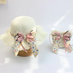 Detailansicht von Strohhut und passender Tasche mit floralen Schleifen für Mädchen