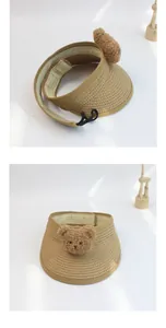 Detail of straw sun visor for kids with cute plush bear patch and adjustable back strap