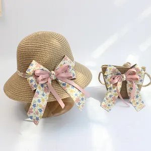 Detail von Mädchen Strohhut und Tasche mit Blumenband und rosa Schleife für Sommer