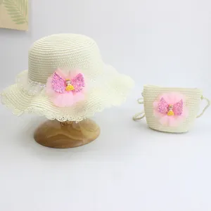 Detail of child's straw hat and matching bag with pink tulle and cute doll decoration