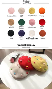 Detail view of wool beret showing colorful pom-poms and variety of 12 stylish colors