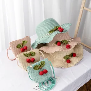 Detail of straw sun hats and matching cherry bags in mint green, pink and beige