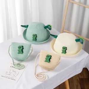 Dettaglio di cappelli di paglia per bambini e borse a tracolla con dinosauri cartone 3D