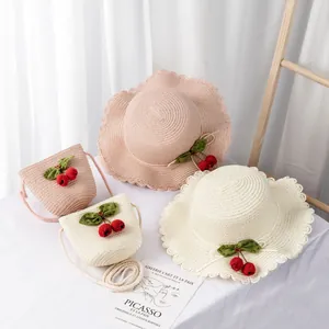 Detail of girls straw hat and matching cherry bag set in pink and beige colors