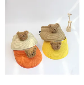 Detail of four colorful woven straw sun visors for kids featuring cute plush bear decor