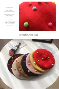 Detail of wool beret featuring colorful pom-poms and a multi-color fan display