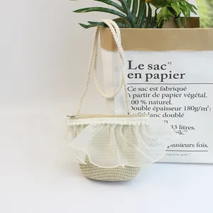 Detail einer beigen Strohtasche mit weißem Netz-Spitzenbesatz und Perlen für Mädchen