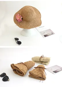 Detail showing the foldable design and pink floral accent of this handmade straw sun hat
