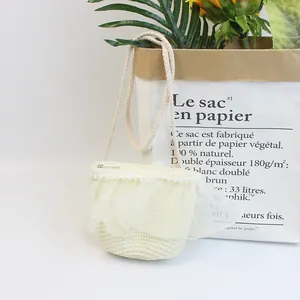 Nahaufnahme der cremefarbenen Strohtasche für Mädchen mit Perlen und Spitzenblumen