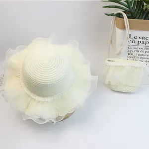 Detail von cremefarbenem Strohhut und Mini-Tasche mit Netzspitze und Perlenbesatz