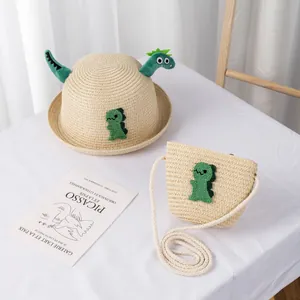 Dettaglio cappello di paglia per bambini e borsa dinosauro con peluche verde carino