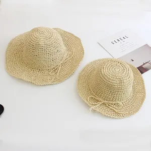 Handwoven beige straw sun hat set for women and kids with bow detail on white background