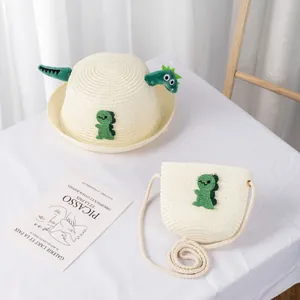 Dettaglio di cappello di paglia per bambini con borsa abbinata e applique di dinosauro