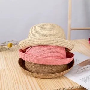 Dettaglio di tre cappelli di paglia impilati che mostrano trame e colori intrecciati