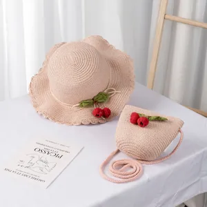 Detail of pink straw hat and crossbody bag with crochet cherry accents for girls