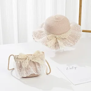 Detail of girls straw sun hat and matching bag set with white lace and ribbon bow