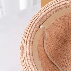 Dettaglio interno del cappello di paglia con trama intrecciata e laccio regolabile