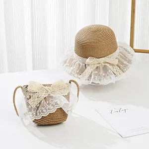 Detail of straw sun hat and matching bag set with white lace trim and floral bow