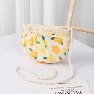 Detalle de bandolera de tela floral con flores amarillas, encaje y correa trenzada