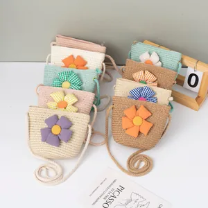 Detailaufnahme handgefertigter Stroh-Minitaschen mit Stoffblumen und geflochtenen Gurten