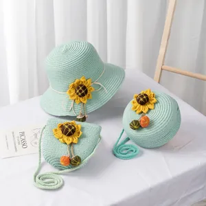 Detail of mint green straw hat and bags set with sunflowers and colorful pom-poms