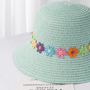Detail von mintgrünem Strohhut mit bunten Blumenstickereien und feiner Webstruktur