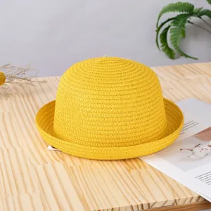 Dettaglio di un cappello di paglia giallo con trama intrecciata e tesa arrotolata