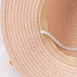 Detailed close-up of woven straw hat featuring sweatband and adjustable elastic strap