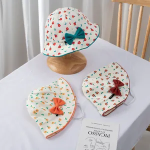 Detailed view of floral baby sun hats with bows and elastic straps for wind protection