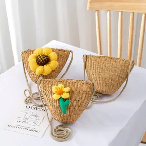 Detailed view of handmade straw crossbody bags with floral accents for summer fashion