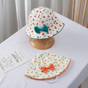 Detail of floral baby sun hats with bows and windproof straps on wooden stand