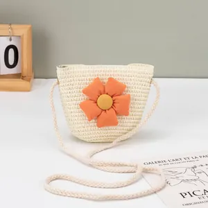 Detailansicht der cremefarbenen Strohtasche mit einer dekorativen orangefarbenen Stoffblume