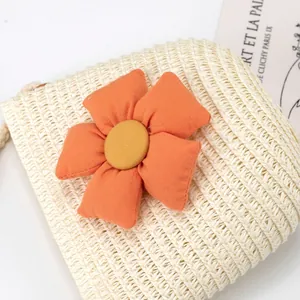 Nahaufnahme der handgefertigten Strohtasche mit großer orangefarbener Blume und Kordel