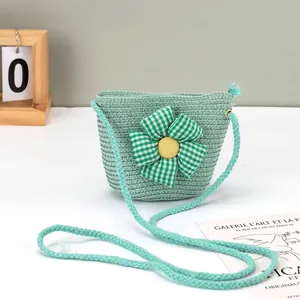 Detail einer hellgrünen Strohtasche mit einer großen grün-weiß karierten Stoffblume darauf