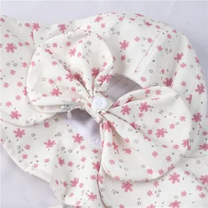 Detail of floral sun hat featuring a large bow with button and invisible zipper texture